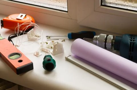 Installation of a window roller with a holder. Installation tool. Screwdrivers,  Stock Photos