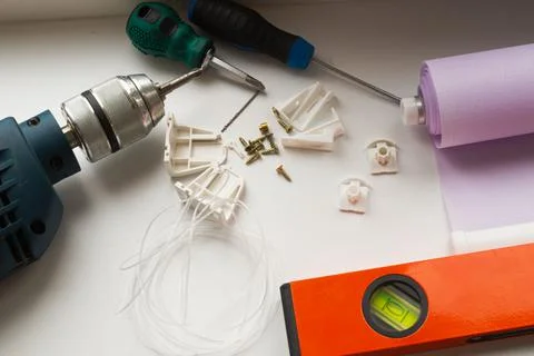 Installation of a window roller with a holder. Installation tool. Screwdrivers,  Stock Photos