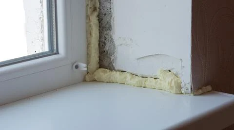 Installation of windows. Polyurethane foam on the slope of the window. Sealin Foto stock
