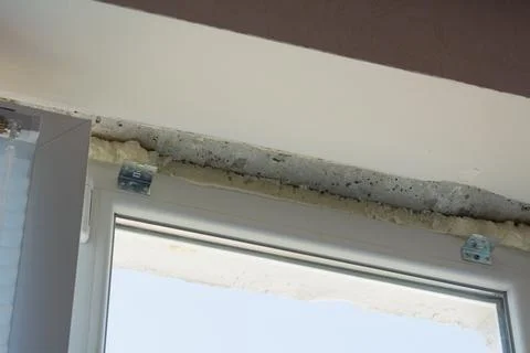 Installation of windows. Polyurethane foam on the slope of the window. Sealin Stock Photos