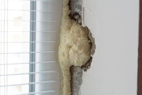 Installation of windows. Polyurethane foam on the slope of the window. Sealin Stock Photos