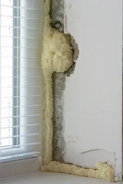 Installation of windows. Polyurethane foam on the slope of the window. Sealin Stock Photos