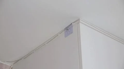 Installation of wireless smoke detector on ceiling corner of white room by Stock Footage 329622116