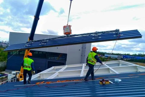 Installation work on the installation of sandwich panels on the roof of an .. Stock Photos