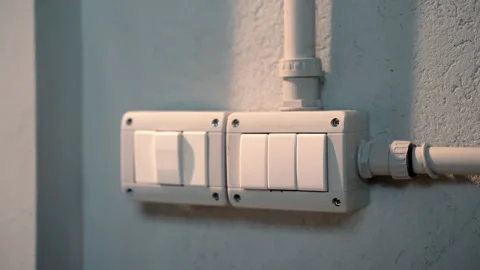 Installed electricity switch on grey wall, plastic outer box with white buttons Stock-Footage 250484464