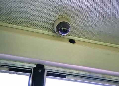 An installed wide angle surveillance camera inside school bus. Stock Photos