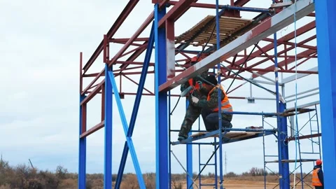 Installer on construction beams puts on a helmet. Safety precautions Stock Footage 321003692