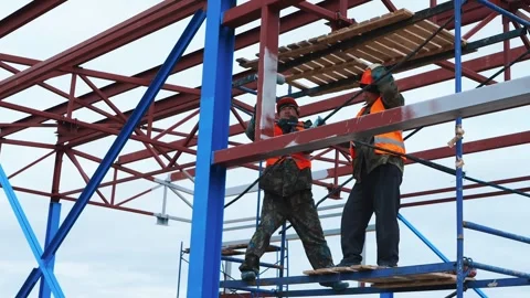Installer on construction beams puts on a helmet. Safety precautions Stock Footage 321003707