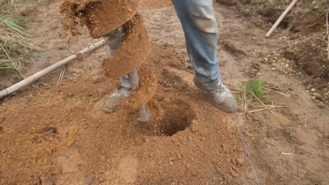 Installer drills post, worker uses auger for holes, installer using earth auger Stock Footage 319402796