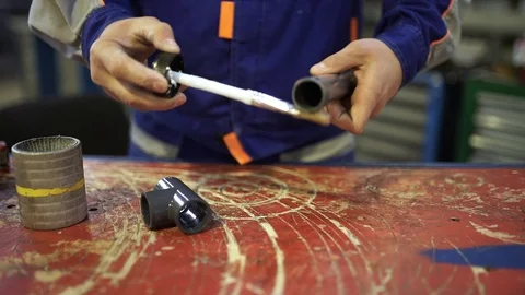 The installer glues a pipe and a fitting made of polyvinyl chloride Stock Footage 92864799