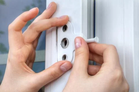 Installer hands close-up, installation of limiter pvc window. Stock Photos