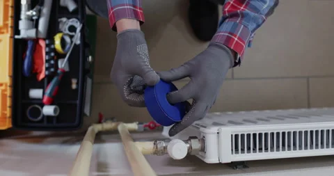 Installer prepares PTFE tape and wraps male thread evenly Stock Footage 322011568