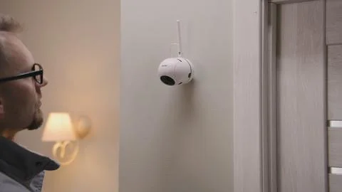 Installer puts security camera on wall mount Stock Photos