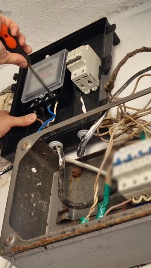 Installer Screwing Electrical Meter into Junction Box Stock Footage 318343227