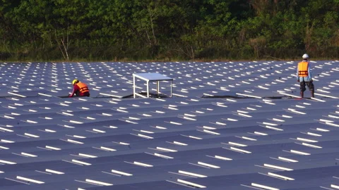 Installing and connecting solar panels on the like the surface of a pond water Stock Footage 248234054