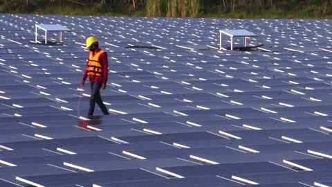 Installing and connecting solar panels on the like the surface of a pond water Stock Footage 248240599