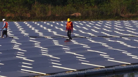 Installing and connecting solar panels on the like the surface of a pond water Stock Footage 248240712