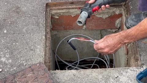 Installing and fusing telephone cables into an outdoor manhole for network .. Stock Footage 291618999