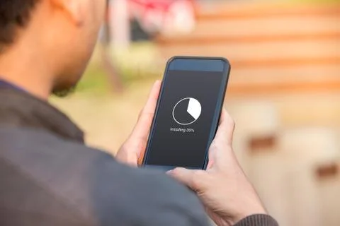 Installing application process on smartphone concept. Man holding smartphone  Stock Photos