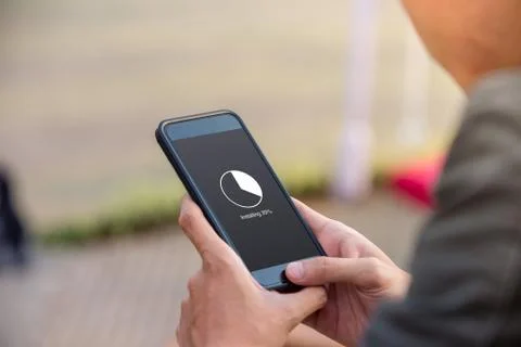 Installing application process on smartphone concept. Man holding smartphone Stock Photos