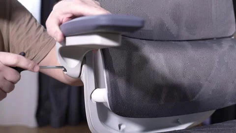 Installing armrest on modern office chair during home furniture assembly Stock Footage 327910169