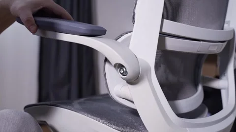 Installing armrest on modern office chair during home furniture assembly Stock Footage 327910177
