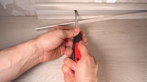 Installing the baseboard with a screwdriver and self-tapping screws Stock Footage 305634996