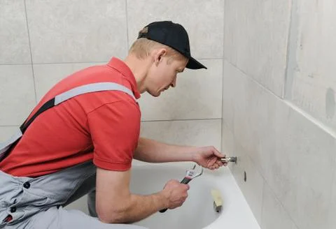 Installing bath faucet. Stock Photos