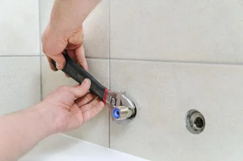 Installing bath faucet. Stock Photos