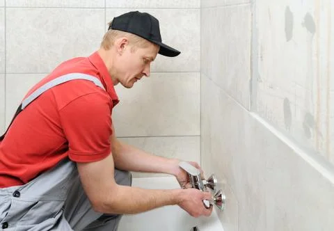 Installing bath faucet. Stock Photos