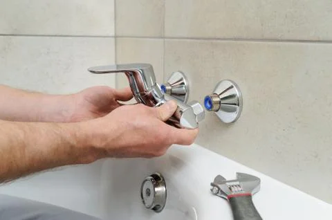 Installing bath faucet. Stock Photos