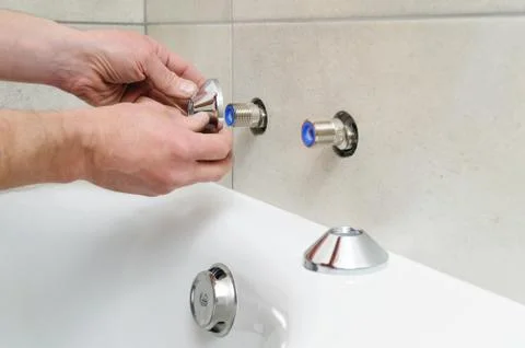 Installing bath faucet. Stock Photos