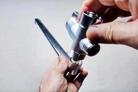 Installing bath mixer tap with long spout using threaded connection. Stock Photos