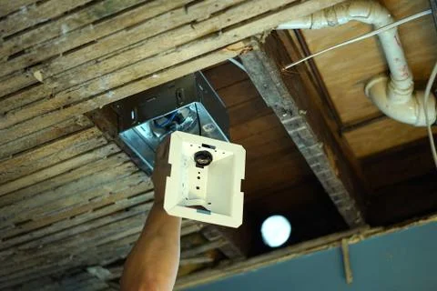 Installing bathroom fan in old ceiling. Stock Photos