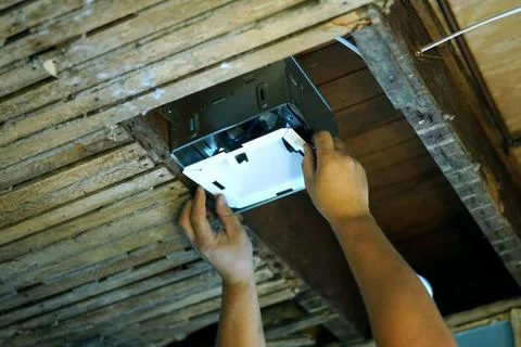 Installing bathroom fan in old ceiling. Stock Photos
