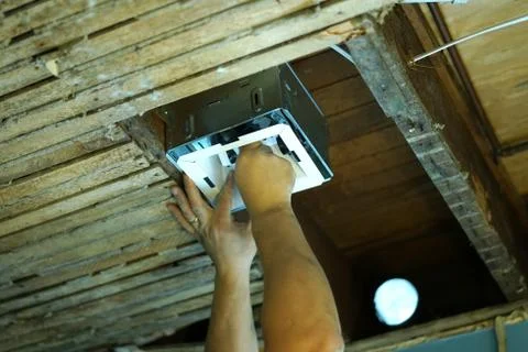 Installing bathroom fan in old ceiling. Stock Photos