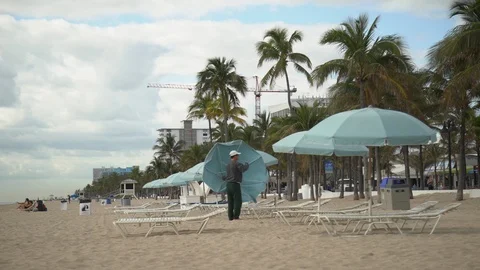 Installing a beach umbrella Vídeos de archivo 87064290
