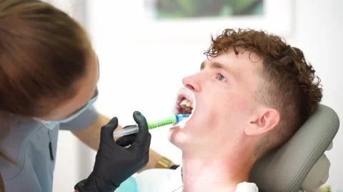 Before installing the brace system, the orthodontist applies the gel to the teet Video stock 167303704