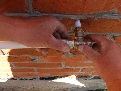 Installing a brass tee during water pipe layout Stock Photos