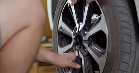 Installing a car wheel 4K60P .Car wheel replacement in workshop. Stock Footage 263143740