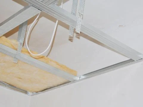 Installing ceiling metal frame with U-shaped brackets and mineral wool insu.. Stock Photos