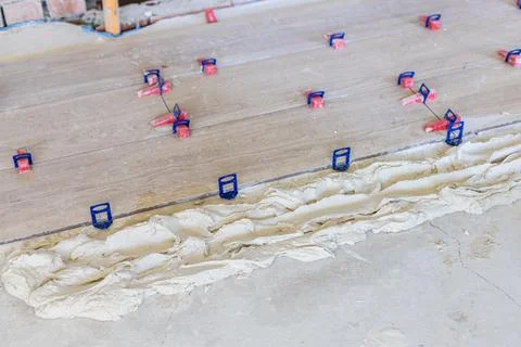 Installing ceramic tiles using a leveling system on a new floor Stock Photos
