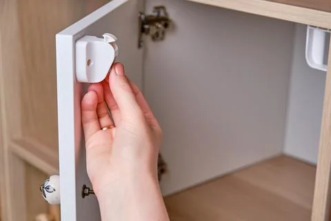 Installing a child-proof magnetic lock to protect cabinet doors and drawers o Foto stock