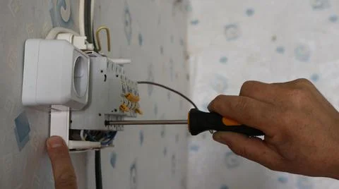 Installing a circuit breaker in an electrical panel with a screwdriver Stock Photos