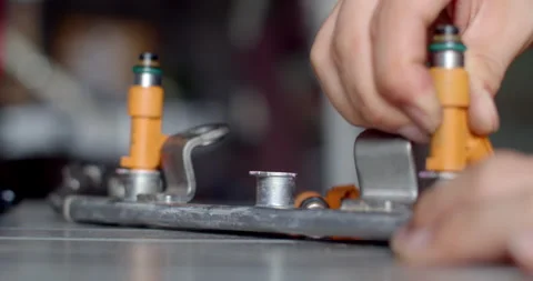 Installing the cleaned fuel injectors back onto the rail making sure. Stock Footage 314768489