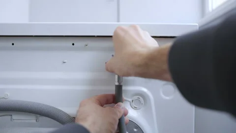 Installing cold water supply hose to the back of the washing machine Stock Footage 159065361