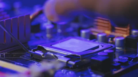 Installing a computer processor CPU. A technician connects a microprocessor to a Stock Footage 194644903