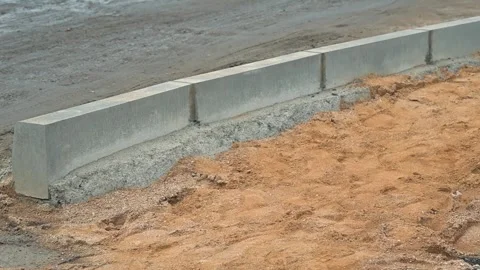 Installing concrete barriers along a new road section in a construction area. Stock Footage 344675505