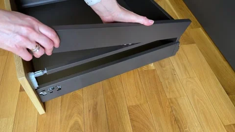 Installing decorative side cover panel on drawer structure close up Stockbeeldmateriaal 333788879