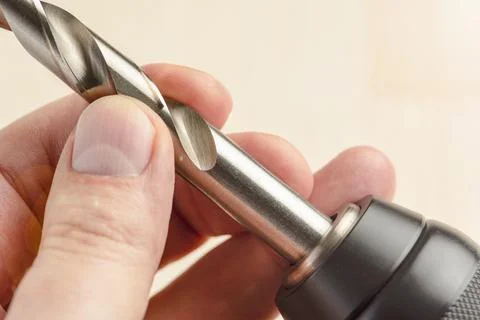 Installing a drill bit in a drill, hands take a drill and install it in a Stock Photos